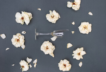 Flat lay pattern with broken glass and withered flower heads on gray background. The concept of...