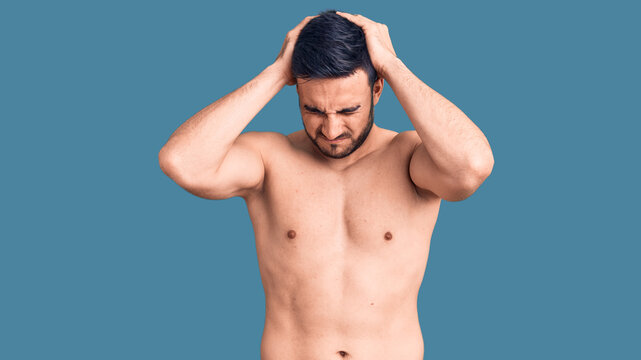 Young handsome man wearing swimwear suffering from headache desperate and stressed because pain and migraine. hands on head.