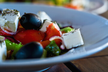 Tasty fresh salad with vegetables on white plate. Selective focus.