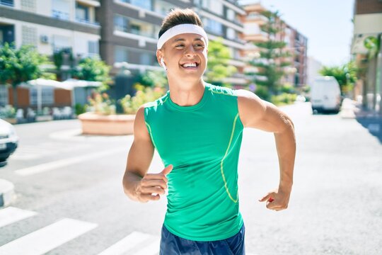 Young hispanic sportsman smiling happy running at street of city