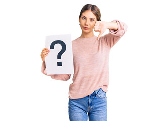 Beautiful caucasian woman with blonde hair holding question mark with angry face, negative sign...