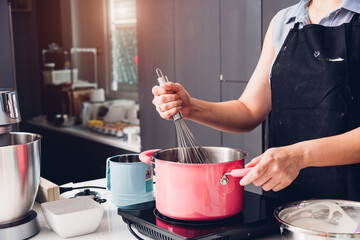 Beautiful woman cooking whisk dough in bowl manual by hands at homemade
