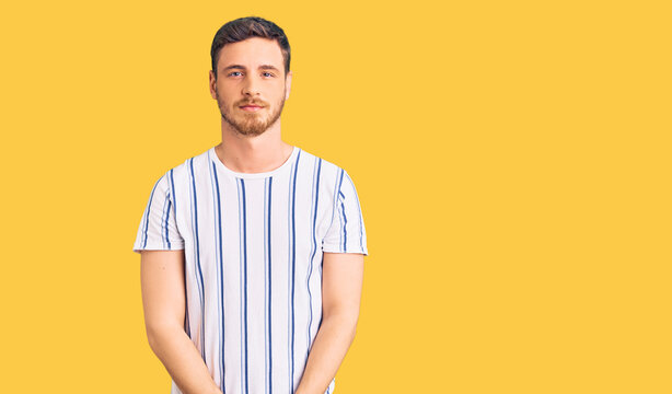 Handsome young man with bear wearing casual clothes with serious expression on face. simple and natural looking at the camera.