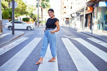 Beautiful young woman wearing fashionable clothes standing in the middle of the street at the town
