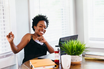 Woman excited after successful video chat meeting working from home