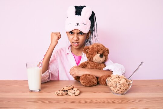 Young African American Girl Child With Braids Wearing Pajama And Having Dinner Annoyed And Frustrated Shouting With Anger, Yelling Crazy With Anger And Hand Raised