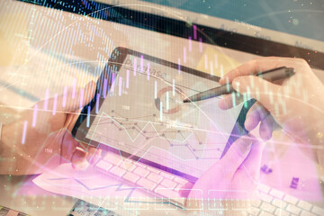 Double exposure of man's hands holding and using a phone and financial chart drawing. Market analysis concept.