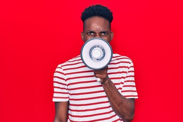 Young african man shouting angry throught megaphone