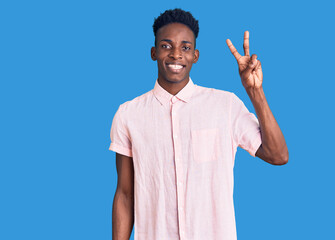 Young african american man wearing casual clothes showing and pointing up with fingers number two while smiling confident and happy.