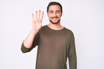 Young handsome man wearing casual clothes showing and pointing up with fingers number four while smiling confident and happy.