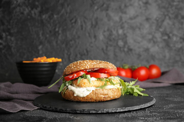 Tasty vegan burger on dark background