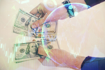 Multi exposure of financial graph drawing hologram and USA dollars bills and man hands. Analysis concept.