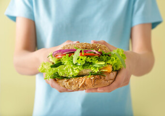 Woman with tasty vegan burger, closeup