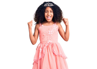 African american child with curly hair wearing princess crown screaming proud, celebrating victory and success very excited with raised arms