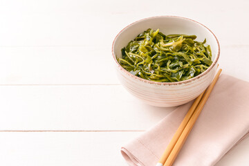 Bowl with tasty seaweed on table