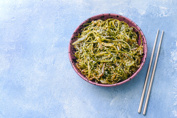 Fototapeta na wymiar Plate with tasty seaweed on color background