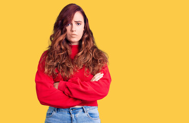 Young beautiful woman wearing casual winter sweater skeptic and nervous, disapproving expression on face with crossed arms. negative person.