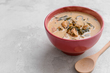 Bowl with tasty seaweed soup on light background