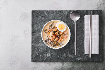 Bowl with tasty seaweed soup on grey background