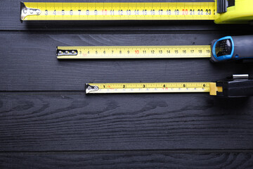 Measuring tapes on wooden background
