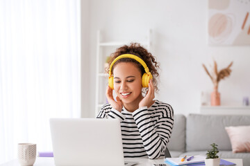 Young woman using laptop for online learning at home