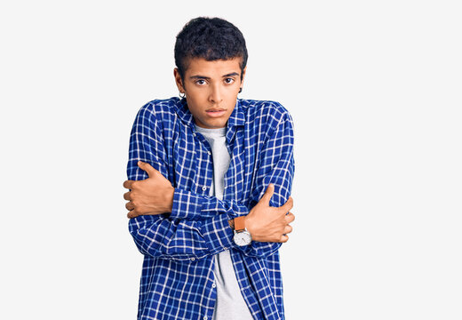 Young african amercian man wearing casual clothes shaking and freezing for winter cold with sad and shock expression on face