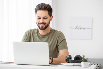 Young man using laptop for online learning at home