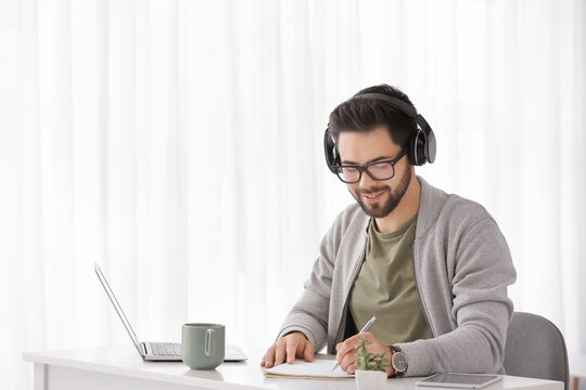 Young Man Using Laptop For Online Learning At Home