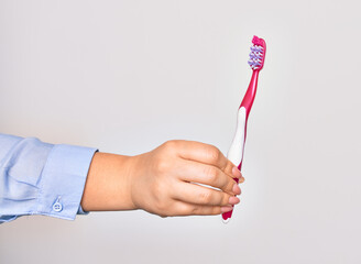 Hand of caucasian young woman holding toothbrush over isolated white background