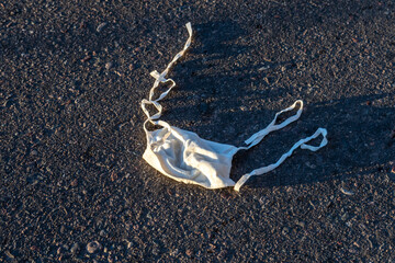 Dirty mask lying on the ground - sunset - Covid - 19