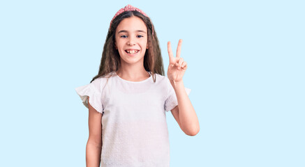 Cute hispanic child girl wearing casual white tshirt showing and pointing up with fingers number two while smiling confident and happy.