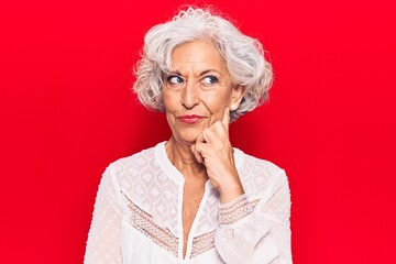 Senior grey-haired woman wearing casual clothes thinking concentrated about doubt with finger on chin and looking up wondering