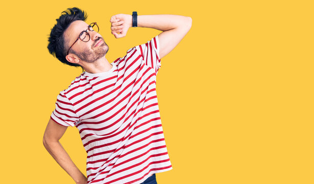 Young hispanic man wearing casual clothes stretching back, tired and relaxed, sleepy and yawning for early morning