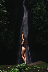 young woman backpacker looking at the waterfall in jungles. Ecotourism concept image travel girl