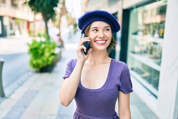 Young beautiful girl smiling happy with french style using smartphone at street of city