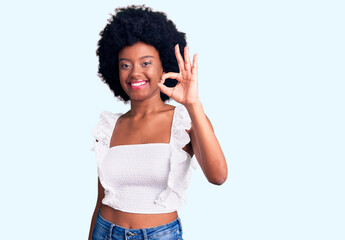 Young african american woman wearing casual clothes smiling positive doing ok sign with hand and fingers. successful expression.