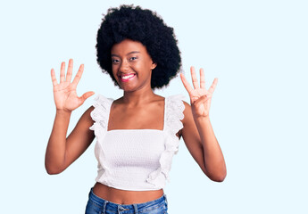 Young african american woman wearing casual clothes showing and pointing up with fingers number...