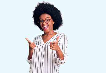 Young african american woman wearing casual clothes and glasses pointing fingers to camera with happy and funny face. good energy and vibes.