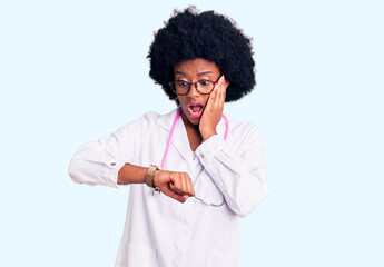 Young african american woman wearing doctor coat and stethoscope looking at the watch time worried,...