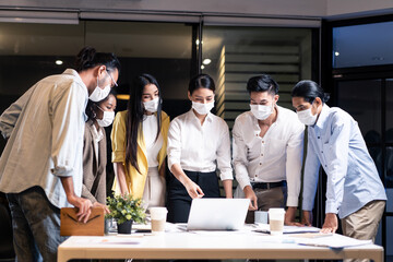 Late working of Asian business people with mask meeting in office