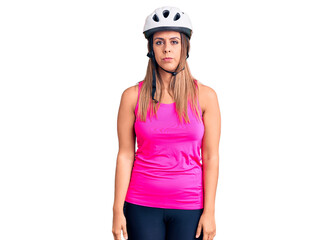 Young beautiful woman wearing bike helmet with serious expression on face. simple and natural looking at the camera.