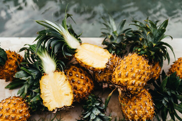 Healthy Raw Organic Food. Fresh Ripe Pineapples near Pure Water In Swimming Pool. Juicy Fruit. Vegetarian, Vegan Nutrition, Lifestyle. Eating Vitamins. Diet, Beauty, Health, Hydration Concept