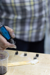 Tattoo artist holding a tattoo machine and dip into inks for tattooing