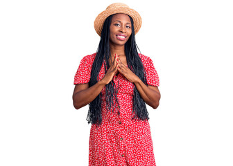Young african american woman wearing summer hat hands together and fingers crossed smiling relaxed and cheerful. success and optimistic