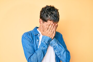 Young handsome man wearing casual clothes with sad expression covering face with hands while crying. depression concept.