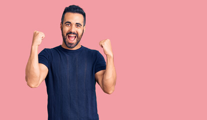 Young hispanic man wearing casual clothes screaming proud, celebrating victory and success very excited with raised arms