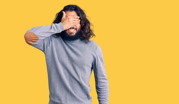 Young arab man wearing casual clothes smiling and laughing with hand on face covering eyes for surprise. blind concept.