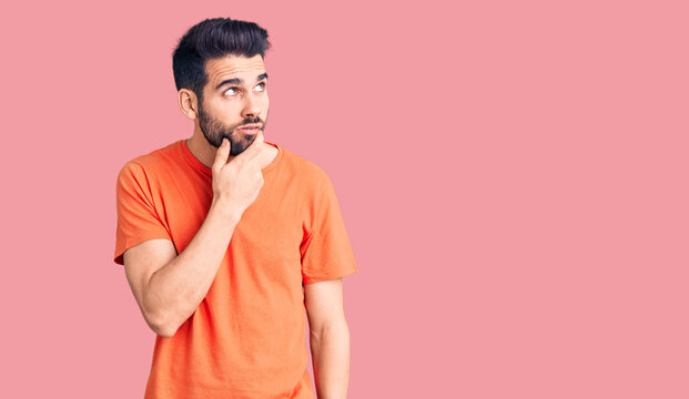 Young handsome man with beard wearing casual t-shirt thinking worried about a question, concerned and nervous with hand on chin