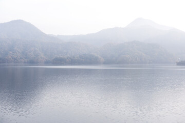 Beautiful autumn scenery,foggy mist over the lake and mountain.