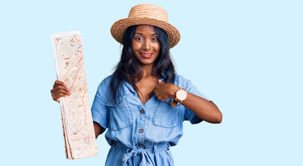 Young indian girl holding city map pointing finger to one self smiling happy and proud